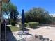 This backyard includes a spacious patio, an umbrella, and mature landscaping at 1281 Challenge Ln, Las Vegas, NV 89110