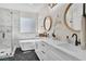 Bathroom featuring double sinks, round mirrors, hexagon tile flooring, and standalone tub with marble accents at 1551 Boundary Peak Way, Las Vegas, NV 89135