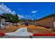 Community playground with slides and seesaw, surrounded by trees and woodchips at 1608 Sussex St # 204, Las Vegas, NV 89144