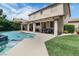 Exterior view of the home's outdoor space featuring a pool, covered patio, and green lawn at 1777 Antelope Valley Ave, Henderson, NV 89012