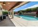 Inviting backyard featuring a covered patio, lush greenery, and a sparkling private pool at 1777 Antelope Valley Ave, Henderson, NV 89012