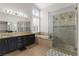 Well-lit bathroom with a double sink vanity, soaking tub, and frameless glass shower at 1777 Antelope Valley Ave, Henderson, NV 89012