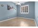 Light blue bedroom with tile flooring, ceiling fan, plantation shutters, and natural light at 1777 Antelope Valley Ave, Henderson, NV 89012