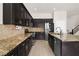 Beautiful kitchen with granite countertops and dark cabinetry offering ample storage at 1777 Antelope Valley Ave, Henderson, NV 89012