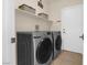 Laundry room featuring tile flooring, a washer and dryer set, and overhead shelving at 1777 Antelope Valley Ave, Henderson, NV 89012
