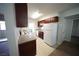 Galley kitchen with white appliances and dark wood cabinets and window views at 2606 S Durango Dr # 264, Las Vegas, NV 89117