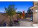 Backyard featuring patio seating, lush landscaping, rock details and a stucco wall at 3 Chatmoss Rd, Henderson, NV 89052