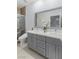 Bathroom with double sink vanity, large mirror, modern fixtures, and tiled shower at 3 Chatmoss Rd, Henderson, NV 89052