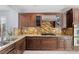A stylish kitchen is equipped with wooden cabinets, granite countertops, and stainless steel appliances at 3 Chatmoss Rd, Henderson, NV 89052