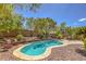 Backyard oasis featuring a pool, lush landscaping, patio furniture and a brick patio at 3 Chatmoss Rd, Henderson, NV 89052