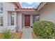 Inviting front entrance with a red door, manicured bushes, and mature desert landscaping at 3109 Siena Cir, Las Vegas, NV 89128