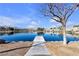 Serene lake view with a path leading to the water, set against a backdrop of homes and distant mountains at 3109 Siena Cir, Las Vegas, NV 89128