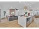 Open-concept living room featuring a modern kitchen island, large sectional sofa, and sleek hardwood flooring at 3109 Siena Cir, Las Vegas, NV 89128