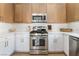 Bright kitchen features stainless steel appliances, white cabinets, and wood flooring at 3436 Camsore Point Ln, Las Vegas, NV 89129