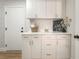 White cabinetry, countertop, and stylish decor enhance the functionality of the laundry area at 3436 Camsore Point Ln, Las Vegas, NV 89129