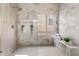 Luxurious shower with marble tile, a built-in bench, and a window providing natural light at 3436 Camsore Point Ln, Las Vegas, NV 89129