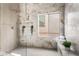 Elegant marble shower with sleek fixtures, a niche for toiletries, and a window at 3436 Camsore Point Ln, Las Vegas, NV 89129