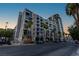 Modern apartment building featuring balconies and palm trees along a city street at 353 E Bonneville Ave # 1302, Las Vegas, NV 89101