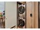Modern laundry room featuring a stacked washer and dryer with custom wood cabinets at 353 E Bonneville Ave # 1302, Las Vegas, NV 89101