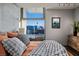 Cozy main bedroom with a view of the city, soft bedding, and natural light at 353 E Bonneville Ave # 1302, Las Vegas, NV 89101