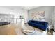 Living room with modern lighting, a blue sofa, hardwood floors, gray accent wall, and contemporary decor at 3740 Caesars Cir, Las Vegas, NV 89120