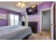 Bedroom featuring purple walls, plush carpet, and a flatscreen television at 3811 Twinkle Star Dr, Las Vegas, NV 89115