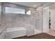 Beautiful bathroom with white marble tile, a sleek tub, and a glass-enclosed shower offering a luxurious spa experience at 4177 Railhead Pass Ave, Las Vegas, NV 89141