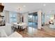 Modern dining area with a white dining table, stylish light fixture, and sliding glass doors to the backyard at 4177 Railhead Pass Ave, Las Vegas, NV 89141