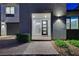 Inviting home entrance showcasing a modern glass-paneled door and stylish exterior lighting at 4177 Railhead Pass Ave, Las Vegas, NV 89141