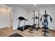 Bright home gym with a treadmill, weight machine, and wood-look flooring, promoting an active lifestyle at 4177 Railhead Pass Ave, Las Vegas, NV 89141