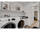 Bright laundry area featuring side-by-side washer and dryer, sleek cabinets, and unique geometric tiled floor design at 4177 Railhead Pass Ave, Las Vegas, NV 89141