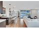Bright, open-concept living room featuring a modern kitchen island with seating and light wood flooring at 4177 Railhead Pass Ave, Las Vegas, NV 89141