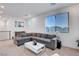 Comfortable living room with large window, gray sectional sofa and view of the neighborhood at 4177 Railhead Pass Ave, Las Vegas, NV 89141