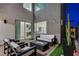 Chic patio with modern seating, a fire pit, and an open view into the home's interior at 4177 Railhead Pass Ave, Las Vegas, NV 89141