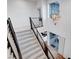 Bright stairway with carpeted steps, modern railing, and a stylish, multi-bulb chandelier at 4177 Railhead Pass Ave, Las Vegas, NV 89141