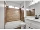 Bathroom with wood-style tile accent wall, modern fixtures, and a shower-tub combo at 4205 Caliper Dr, Las Vegas, NV 89110