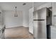 Open floor plan featuring a stainless steel refrigerator and adjacent dining area with modern light fixture at 4205 Caliper Dr, Las Vegas, NV 89110