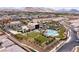 Stunning aerial view of the community amenities, including a pool, lush green spaces, and mountains in the distance at 4289 Sunrise Flats St, Las Vegas, NV 89135