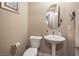 Stylish half bathroom with a pedestal sink, modern fixtures, and neutral color palette at 4289 Sunrise Flats St, Las Vegas, NV 89135