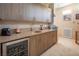 Modern wet bar with wood cabinets, beverage cooler, sink and stone countertops at 4289 Sunrise Flats St, Las Vegas, NV 89135