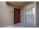 Condominium entrance with a maroon door and a window at 5055 W Hacienda Ave # 2125, Las Vegas, NV 89118