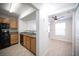 Kitchen view with black appliances, wooden cabinetry, and a view to a spacious living room at 5055 W Hacienda Ave # 2125, Las Vegas, NV 89118
