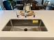 Modern stainless steel kitchen sink with white countertops and dining area in background at 600 N Carriage Hill Dr # 1082, Las Vegas, NV 89138