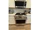 Stainless steel gas range with white cabinets and mosaic tile backsplash at 600 N Carriage Hill Dr # 1082, Las Vegas, NV 89138