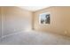 Bright, carpeted bedroom featuring a window with outdoor views and neutral wall paint at 7098 Seabirds Pl, North Las Vegas, NV 89084