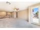 Bright bonus room featuring neutral carpet, a ceiling fan, and sliding doors leading to the balcony at 7098 Seabirds Pl, North Las Vegas, NV 89084