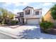 Inviting two-story house featuring a balcony, double front door, and attached two-car garage at 7098 Seabirds Pl, North Las Vegas, NV 89084