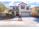 Two-story home with white exterior, balcony, double front door, and well-kept landscaping at 7098 Seabirds Pl, North Las Vegas, NV 89084