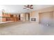 Open-concept living room with fireplace, carpeted floors, and access to the modern kitchen at 7098 Seabirds Pl, North Las Vegas, NV 89084