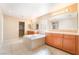 Bright Primary bathroom features dual vanities, soaking tub, tile floors, and walk-in closet at 7098 Seabirds Pl, North Las Vegas, NV 89084